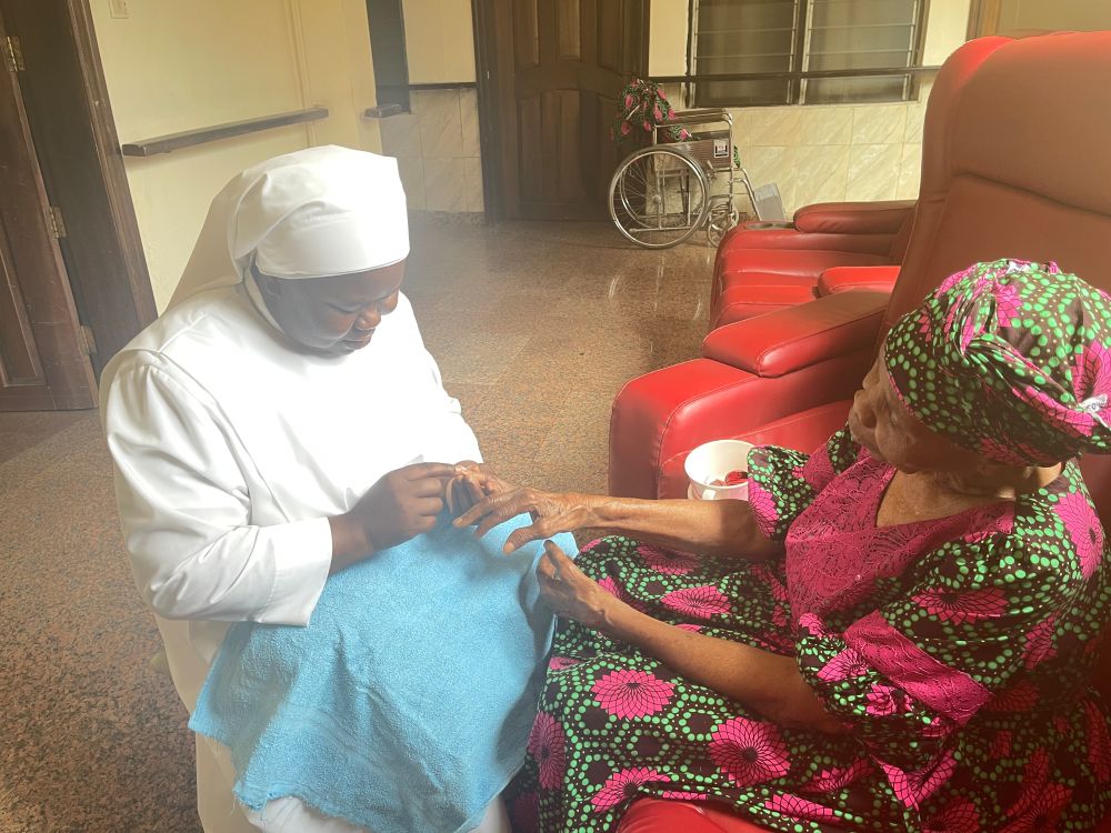Sr. Gertrude Anozie trims a female resident's nails at the Our Lady of Perpetual Help Home for the Elderly in the Awkunanaw area of Enugu, southeastern Nigeria. (John Chukwu)