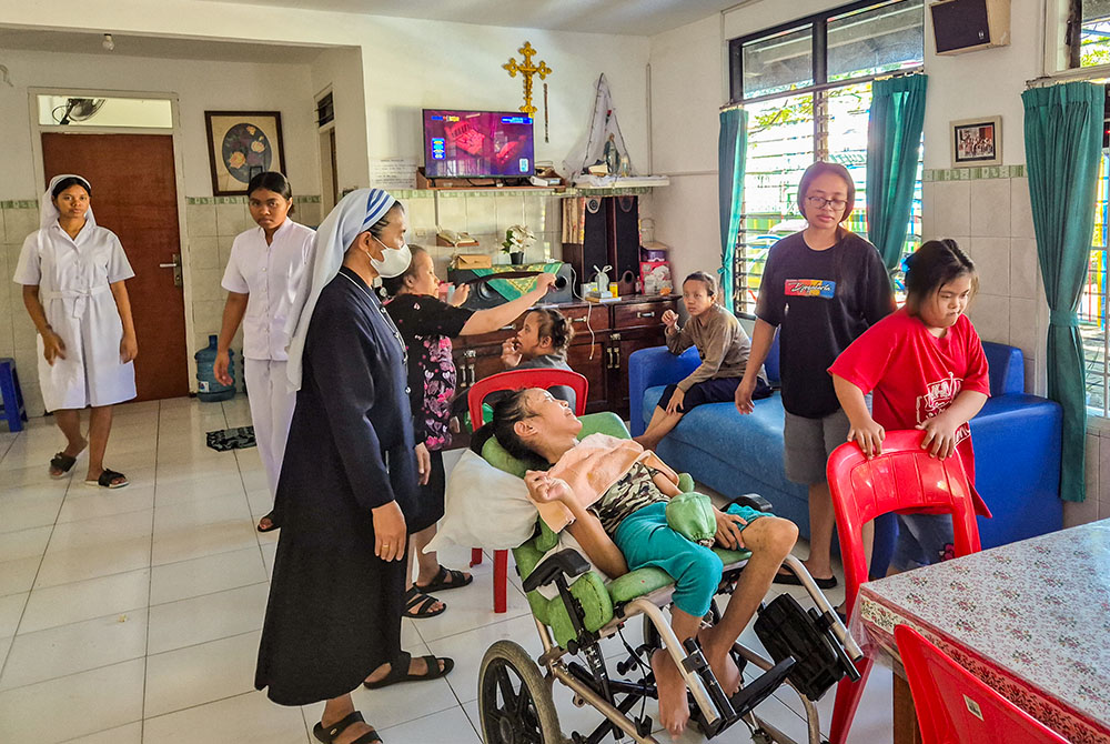 Sr. Catharina Ginah cares for children and adolescents with disabilities at Bhakti Luhur, a care home overseen by the sisters of the Association of Lay Missionary Institutions, while her lay partner assists in the background. (Jacobus Lato)