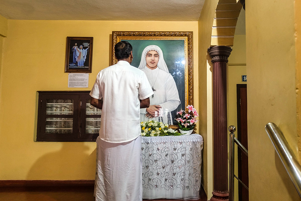 A man prays before a portrait of Venerable Sr. Maria Celine Kannanaikal at the  provincial house of the Ursulines of Mary Immaculate in Payyambalam, a suburb of Kannur town in the southwestern Indian state of Kerala. (George Kommattam)