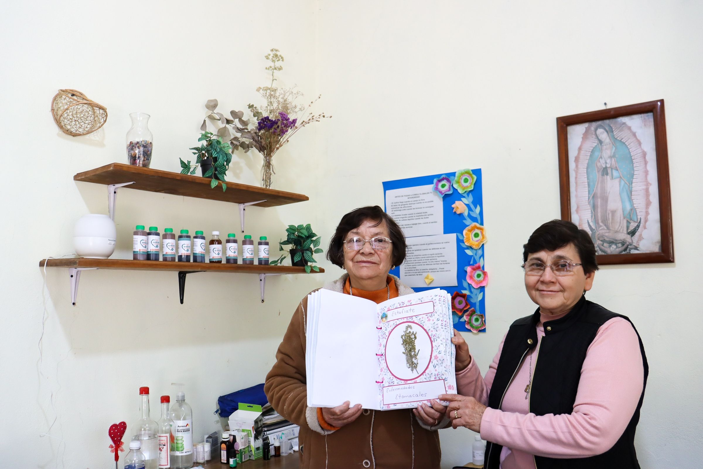Las hermanas María del Socorro Jáuregui y Conchita Antúnez, de la congregación de Hermanas del Corazón de Jesús Sacramentado, sostienen un herbario elaborado en los talleres de medicina tradicional en San Juanito, Chihuahua, México. Con esos talleres, iniciados en 2003, atienden hoy a 13 comunidades. (Foto: Eduardo Cordero)