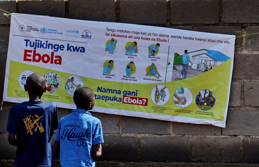 Congolese children read an advocacy poster in Bunia, Congo, May 20, 2026, as aid agencies intensify efforts to contain a new Ebola outbreak caused by the Bundibugyo strain outbreak. (OSV News/Reuters/Gradel Muyisa Mumbere)