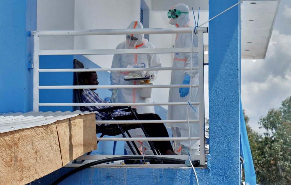 Congolese medical workers dressed in their personal protective equipment, or PPE, talk to a patient June 9, 2026, at the Centre Medical Evangelique, which is within the secured Ebola response zone. (OSV News/Reuters/Gradel Muyisa Mumbere)