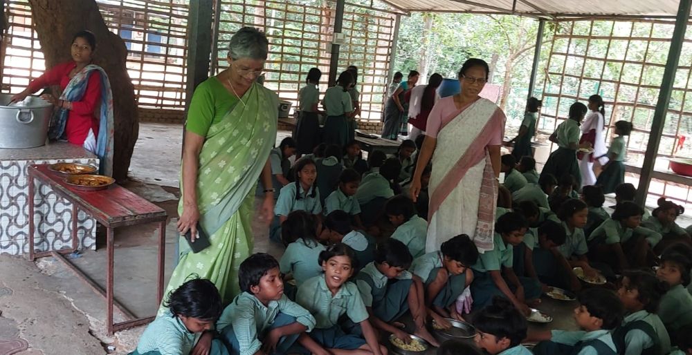 Students of Chirag Vidyalaya in Rajgir, in the eastern Indian state of Bihar, eat lunch in Chetanalaya Hostel Hall, just opposite the school building. Overseeing the lunch distribution are Nazareth Srs. Rose Plathottam (left) and Jyoti Kerketta. (Jose Kalapura)