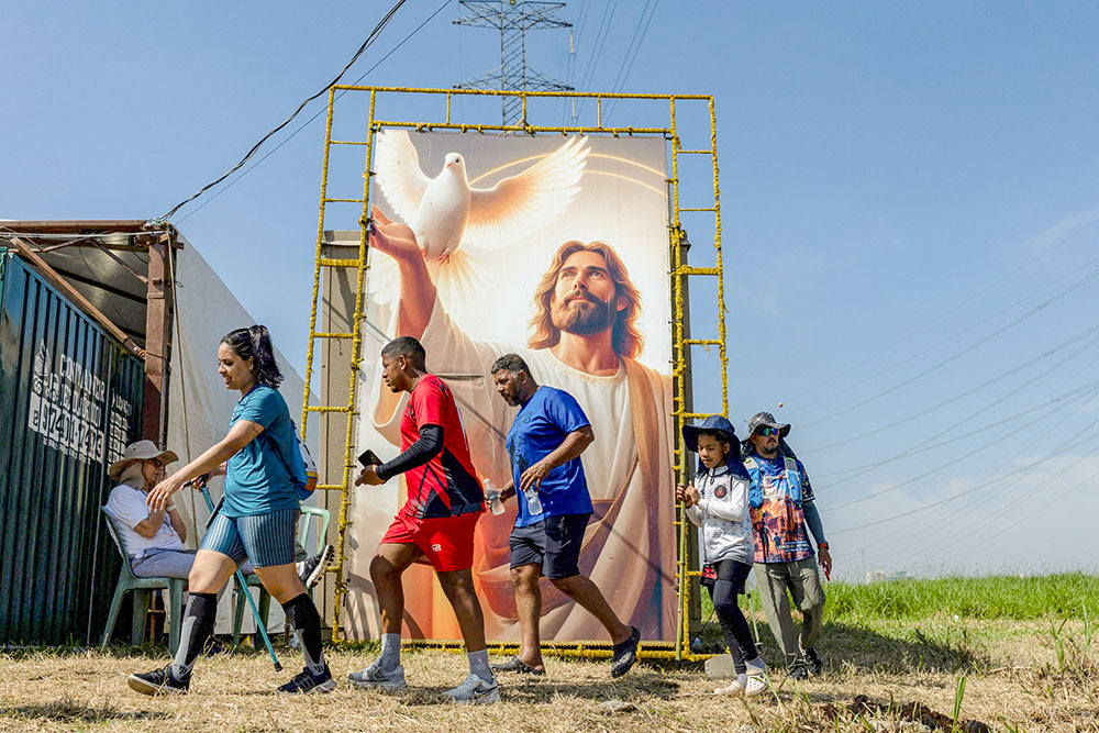 Pilgrims heading to the Basilica of the National Shrine of Our Lady of Aparecida pass a painting of Jesus along the Presidente Dutra Highway in São José dos Campos, Brazil, Oct. 9, 2026. (OSV News/Reuters/Roosevelt Cassio)