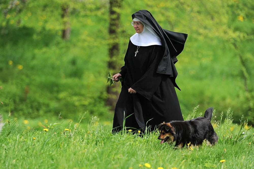 Mother Stefania Polkowska, abbess of the Benedictine Abbey in Staniatki, walks with the monastery dog on the abbey grounds in Staniatki, Poland, in an undated photo. (OSV News/Courtesy of Benedictine Abbey in Staniatki)