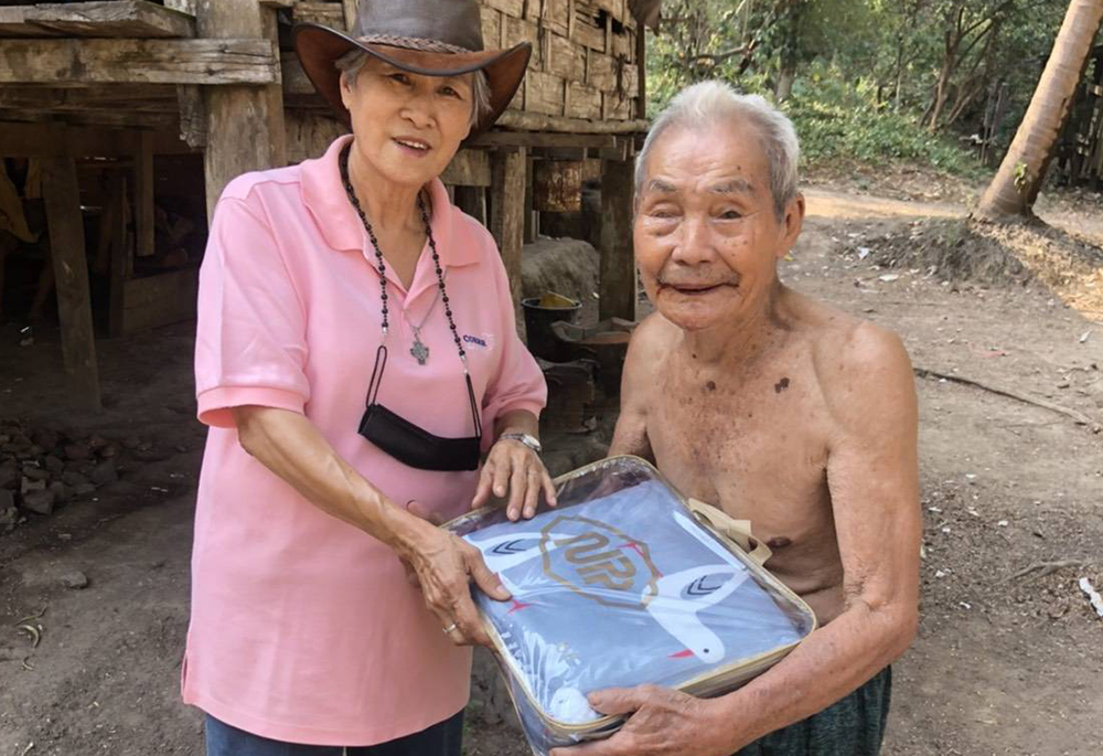 Presentation Sr. Cecilia Phetpanomporn gives blankets to a refugee at a camp on the border between Thailand and Myanmar. (Courtesy of Good Shepherd International Foundation)