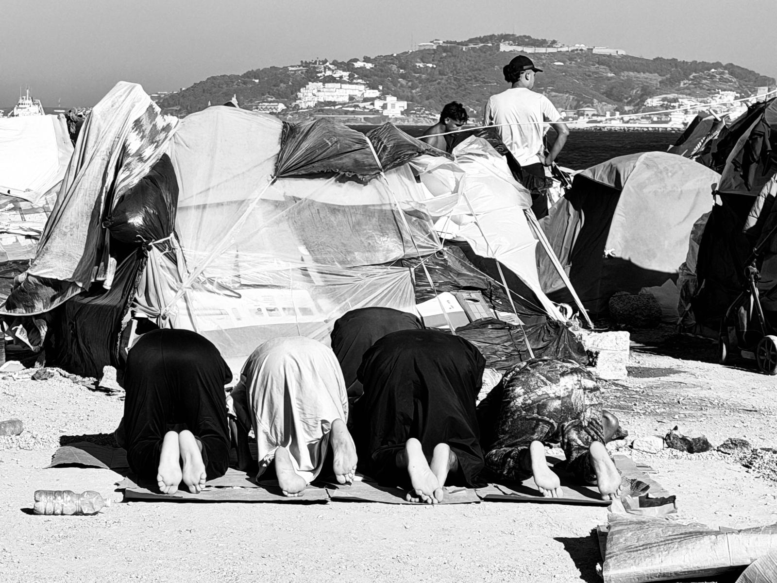 Mujeres migrantes oran arrodilladas en Ceuta, en el contexto de la llegada masiva desde Marruecos a Ceuta, ciudad española en África, de más de 70 000 personas a finales de julio de 2026. (Foto: cortesía Mari Carmen Sapiña)