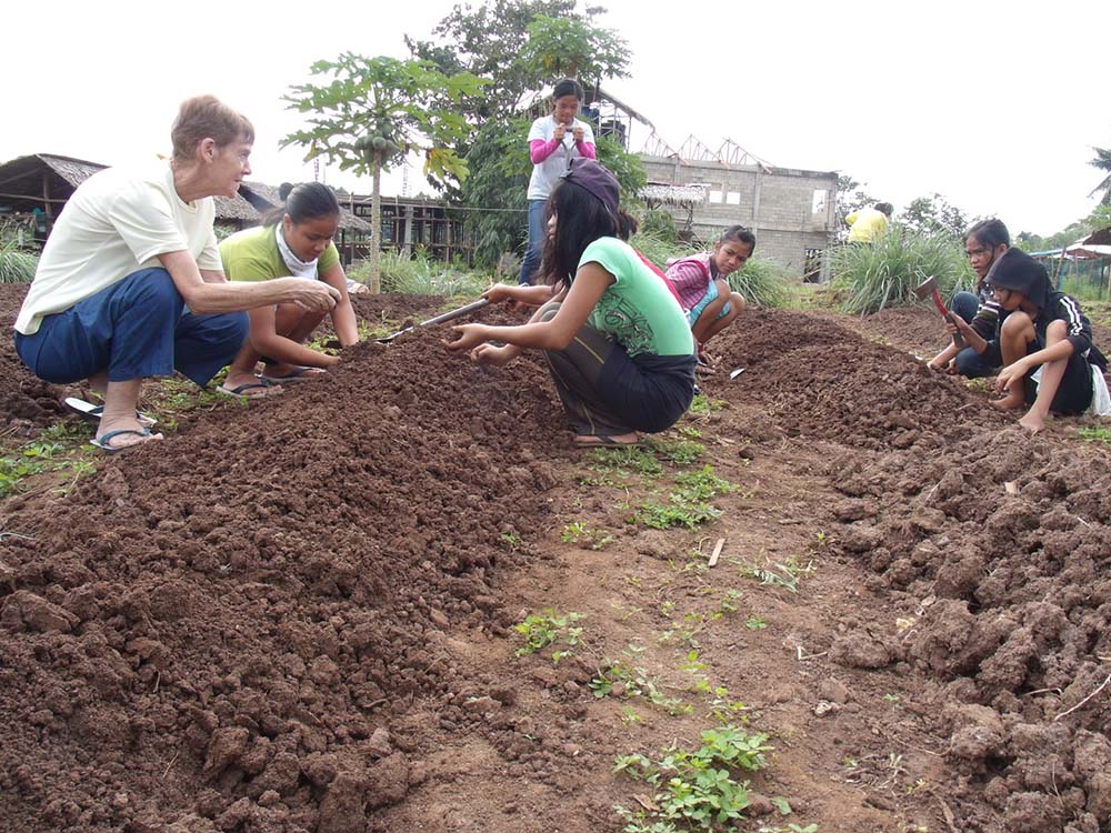 Sr. Patricia Fox joins children in a sustainable farming project being run by the Salesian sisters in Palawan, Philippines, in 2006. (Courtesy of Patricia Fox)