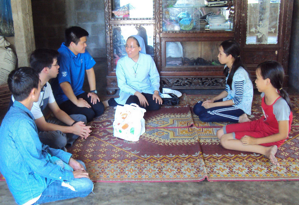 Sr. Mary Nguyen Thi Phuoc Hong tells her vocation story to Catholic volunteers while they visit orphans in Phu Loc district on May 14. (Joachim Pham)