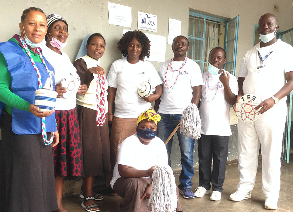 Carmelite Sr. Mildness Chinake, third from left, joins other Jesuit Refugee Service staff in displaying items made by elderly people at the Tongogara Refugee Camp in Zimbabwe. (Courtesy of Mildness Chinake)