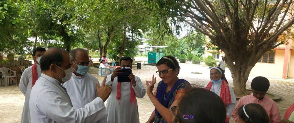 Archbishop Kuriakose Bharanikulangara of Faridabad speaks in sign language with Priya, a woman living in Sanjoe Bhawan, one of the six houses attached to Sanjoepuram Children's Village in Chandpur, India. (Provided photo)