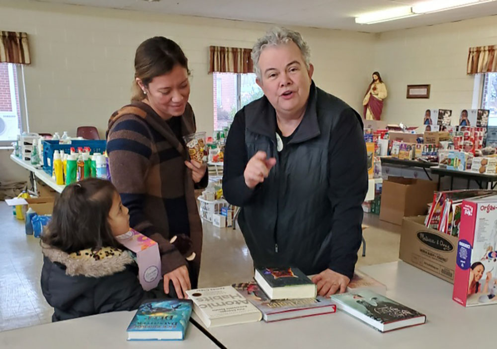 Ursuline Sr. Martha Keller, left, and Maria, a Hispanic tornado survivor, make a plan for her to celebrate Christmas with her young daughter. (Courtesy of Martha Keller)