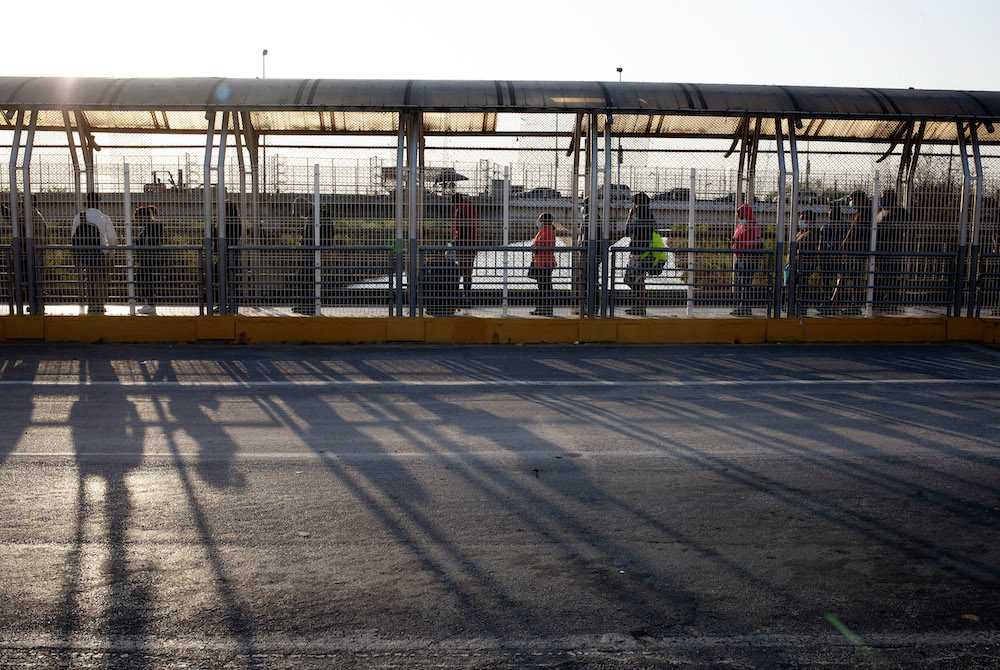 People authorized to cross the U.S.-Mexico border line up on the U.S. side of the McAllen-Hidalgo-Reynosa International Bridge early in the morning of March 22 in McAllen, Texas. (Nuri Vallbona)