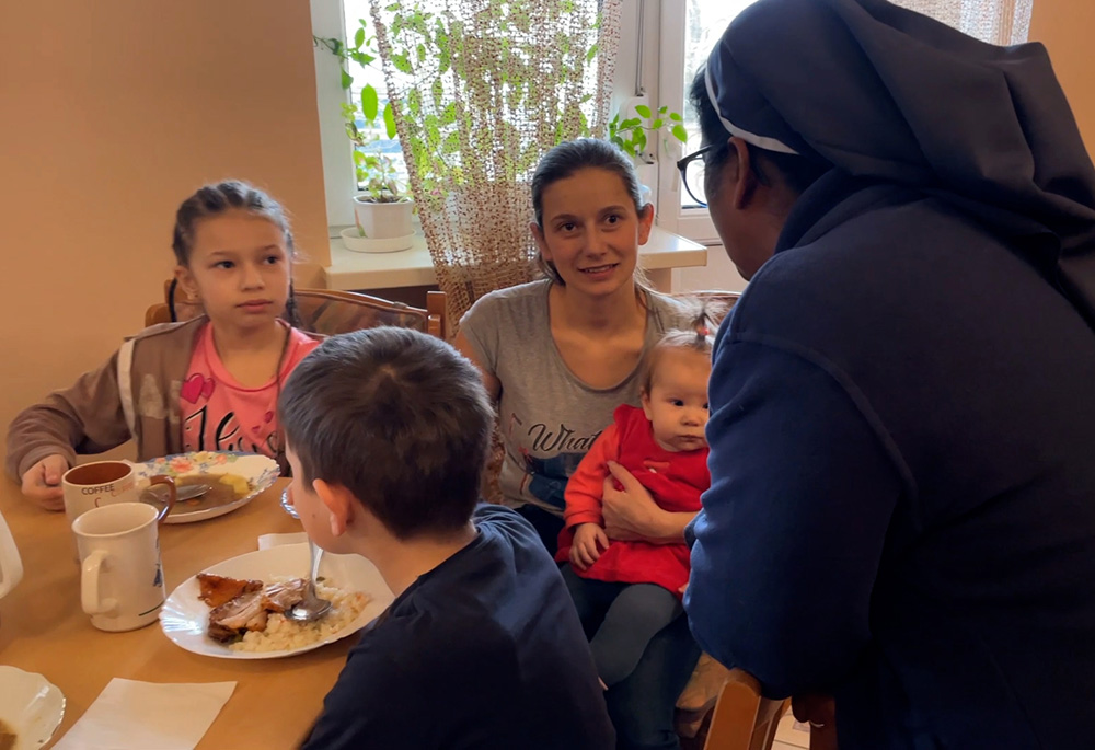 Sr. Ligi Payyappilly converses with women and children at the breakfast table in her convent in Mukachevo, western Ukraine. (Courtesy of Ligi Payyappilly)