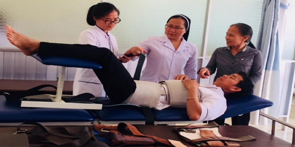 Sr. Mary Nguyen Thi My visits with Sister Ha, who is treating a man with back pain on an electrical therapy bed, at the clinic of the Dominican Sisters of St. Rose of Lima in My Linh, Gia Lai province. (Courtesy of Mary Nguyen Thi My)
