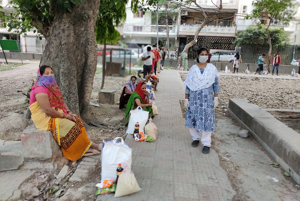 Sr. Rani Punnaserril stands with women waiting to pick up food (Provided photo)