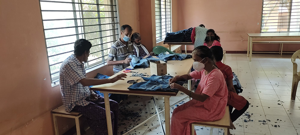 Residents of Support, a home for people with HIV/AIDS, work in a unit for manufacturing garments as part of vocational training on the Sumanahalli campus in Bengaluru, southern India. (Thomas Scaria)