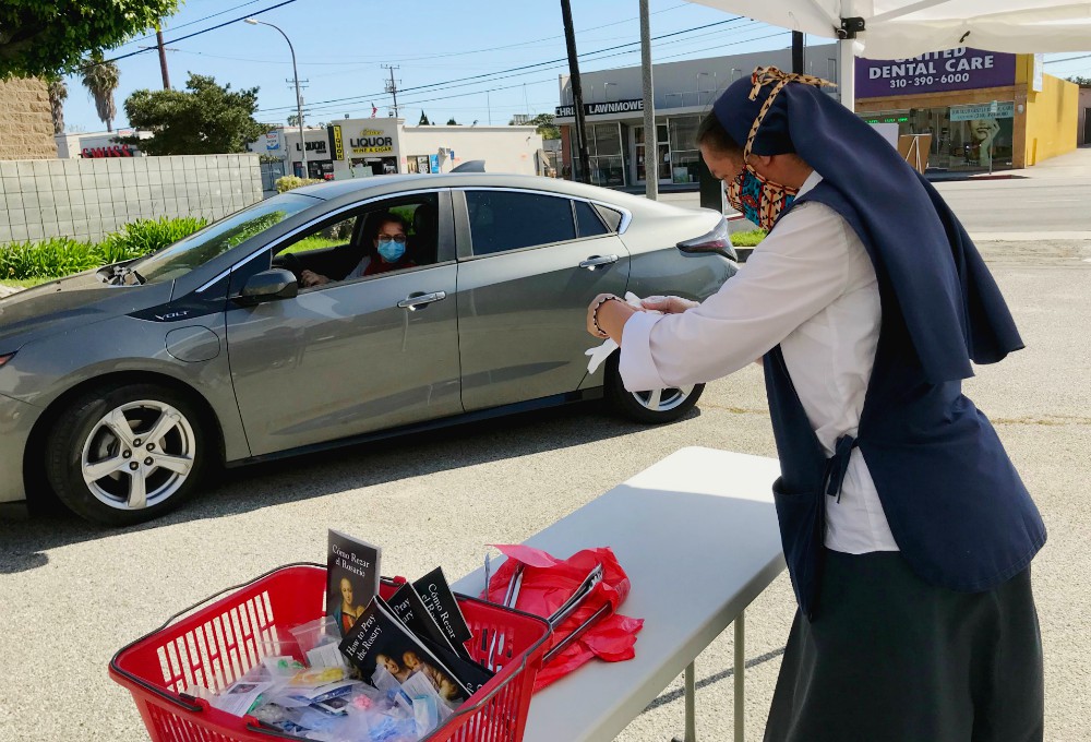 Sr. Mary Jerome Connor prepares individual packages for drivers coming to pick up rosaries during the Daughters of St. Paul's 10-day "pray the rosary to end the pandemic" giveaway in May. (Sr. Rose Pacatte) Sr. Mary Jerome Connor prepares individual packages for drivers coming to pick up rosaries during the Daughters of St. Paul's 10-day "pray the rosary to end the pandemic" giveaway in May. (Sr. Rose Pacatte)