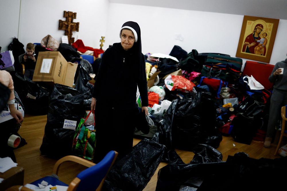 A nun carries humanitarian goods to be loaded onto trucks as first aid transport to Ukraine at the Basilica of Santa Sofia, a religious and cultural center for Ukrainian expatriates in Rome, on March 3. (CNS/Reuters/Guglielmo Mangiapane)