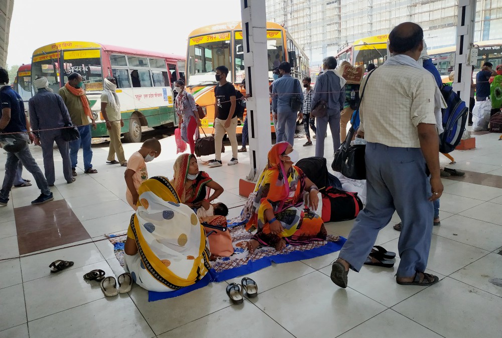 Mothers and children wait at Kaushambi Bus Terminal on the Delhi-Uttar Pradesh border to go to their villages in eastern India hundreds of kilometers away. (Jessy Joseph)