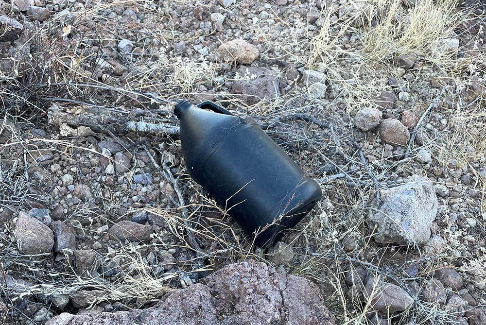 A black empty water container was left by migrants after crossing the border into the U.S. from Mexico. Volunteers who do the desert water drop-offs for migrants pick up the empties as part of their work. (Peter Tran)