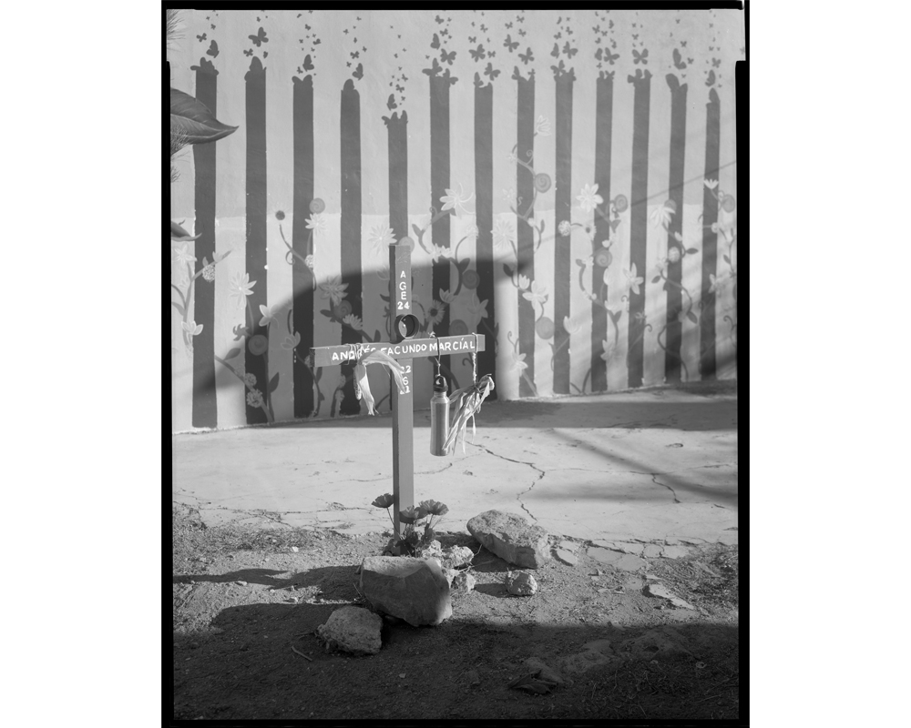 A memorial cross was set up within the migrant center grounds to remember Andrés Facundo Marcíal, a migrant who died of thirst in the desert on June 22, 2021, at age 24. (Lisa Elmaleh)