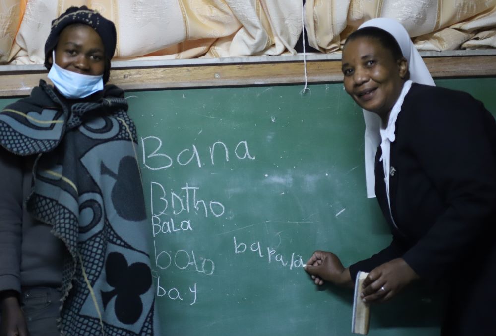 La Hna. Amelia Dikiso, que pertenece a las Hermanas del Buen Pastor de Quebec, enseña a un niño pastor a juntar letras para formar palabras en la Escuela Nocturna del Buen Pastor en Semonkong, una pequeña ciudad del altiplano a unos 115 kilómetros al sureste de Maseru, la capital de Lesoto. (Foto: GSR/Doreen Ajiambo)