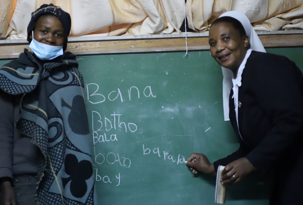Sr. Amelia Dikiso, a member of the Good Shepherd Sisters of Quebec, teaches a herd boy how to put letters together to form words at the Good Shepherd Night School in Semonkong, Lesotho. (GSR photo/Doreen Ajiambo)