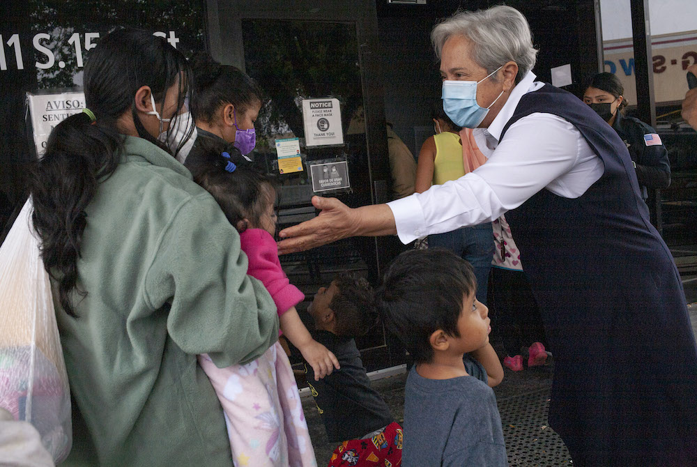 Sr. Norma Pimentel, a member of the Missionaries of Jesus and executive director of Catholic Charities of the Rio Grande Valley, greets newly arrived immigrants March 23 at the Humanitarian Respite Center in McAllen, Texas. (Nuri Vallbona)