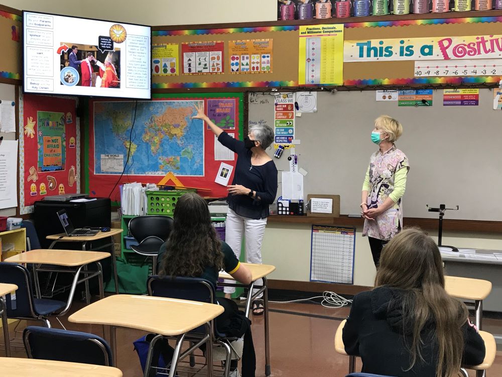 Religious education teacher Tamara de Dios, left, and Bernadette Michael, a faith formation assistant, chat with students preparing for confirmation in a class Oct. 26, 2021, at St. Agnes School in Arlington, Virginia. 