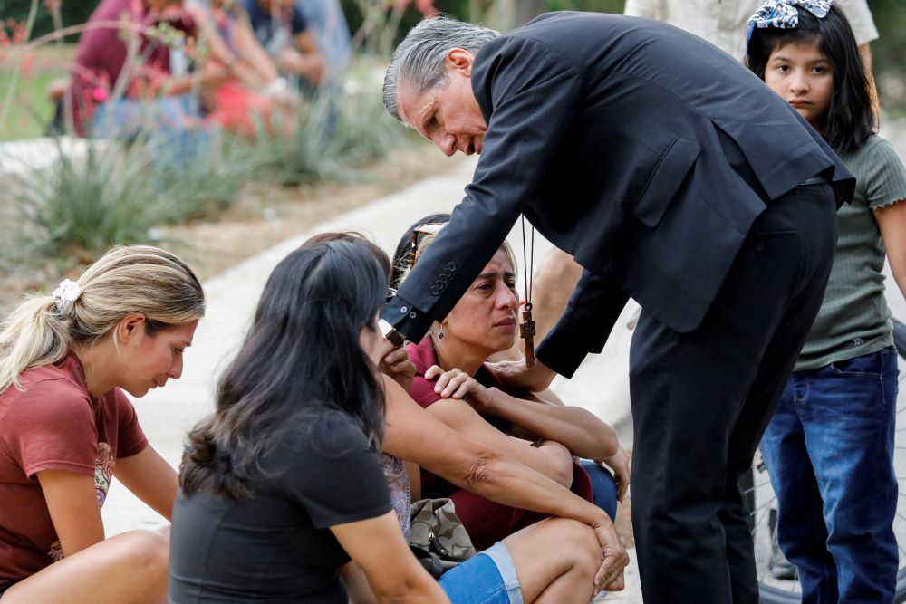 Archbishop Gustavo García-Siller of San Antonio comforts people in Uvalde, Texas, outside the SSGT Willie de Leon Civic Center, where students had been transported from Robb Elementary School after a mass shooting May 24. (CNS/Reuters/Marco Bello)