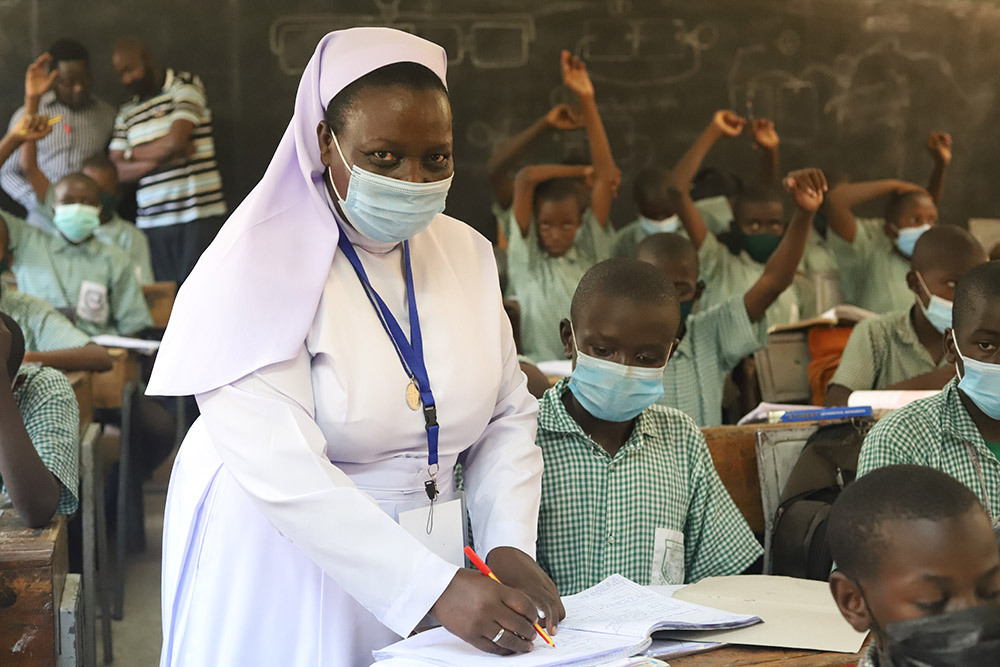Sr. Anne Onyancha helps a boy with his studies at St. Peter's Mumias Boys Primary School in Kakamega, Kenya. (GSR photo/Doreen Ajiambo)