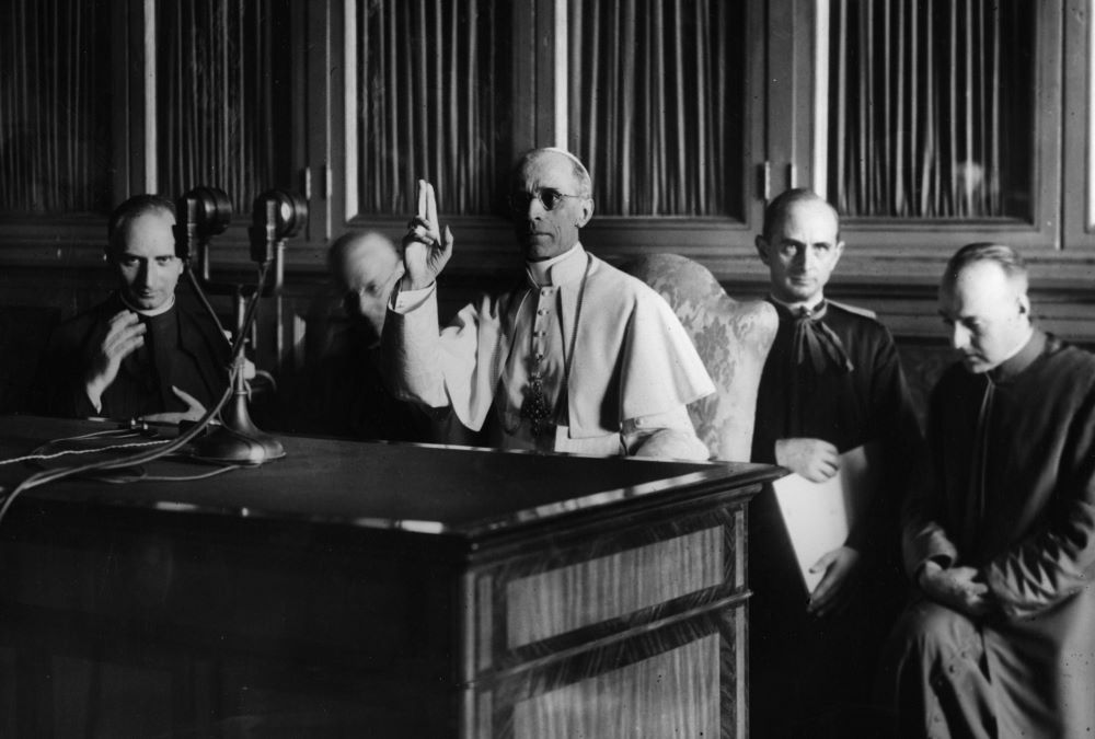 Pope Pius XII gives a blessing at the end of a radio message Sept. 1, 1943. (CNS)