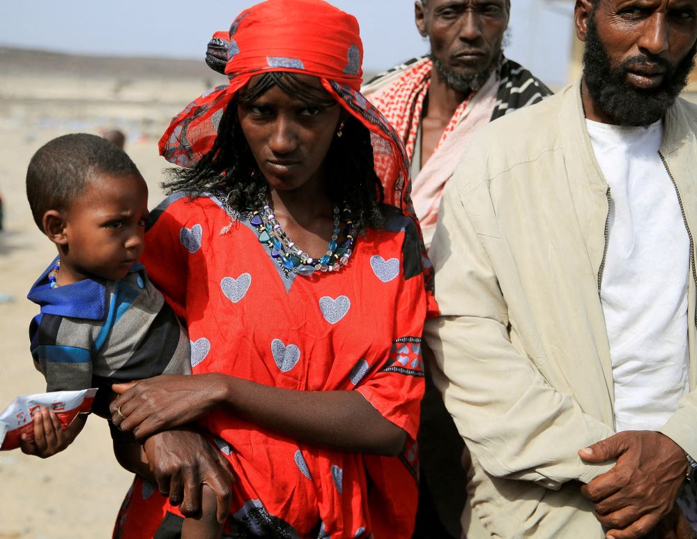 People who fled their homes because of fighting between the Afar Special Forces and the Tigray People's Liberation Front in Berhale, Ethiopia, wait for food near a makeshift compound in Afdera district Feb. 23. (CNS/Reuters/Tiksa Negeri)