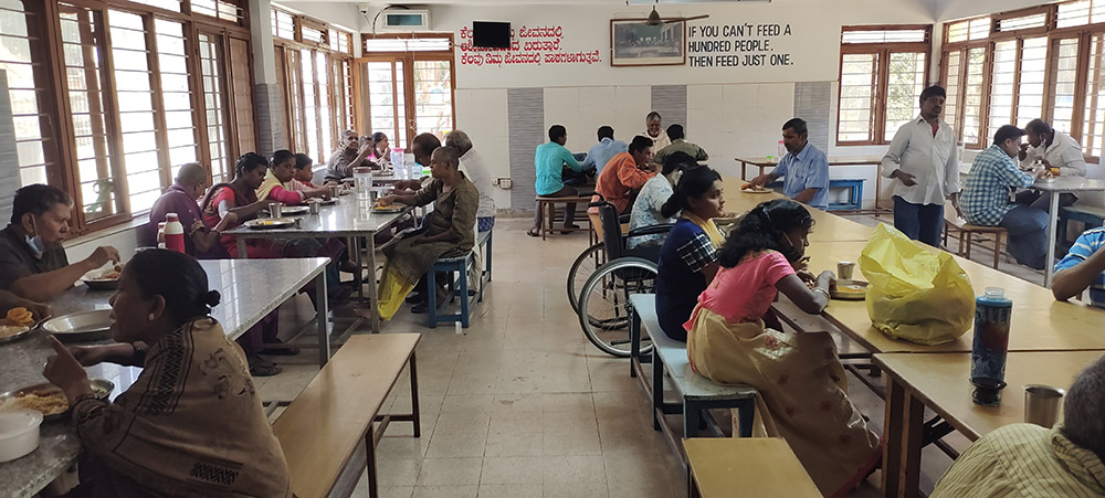 The residents of Sumanahalli share lunch with the sisters, volunteers and staff. On the day GSR visited Sumanahalli, the food was served by a Hindu family in a celebration marking their wedding anniversary. (Thomas Scaria)