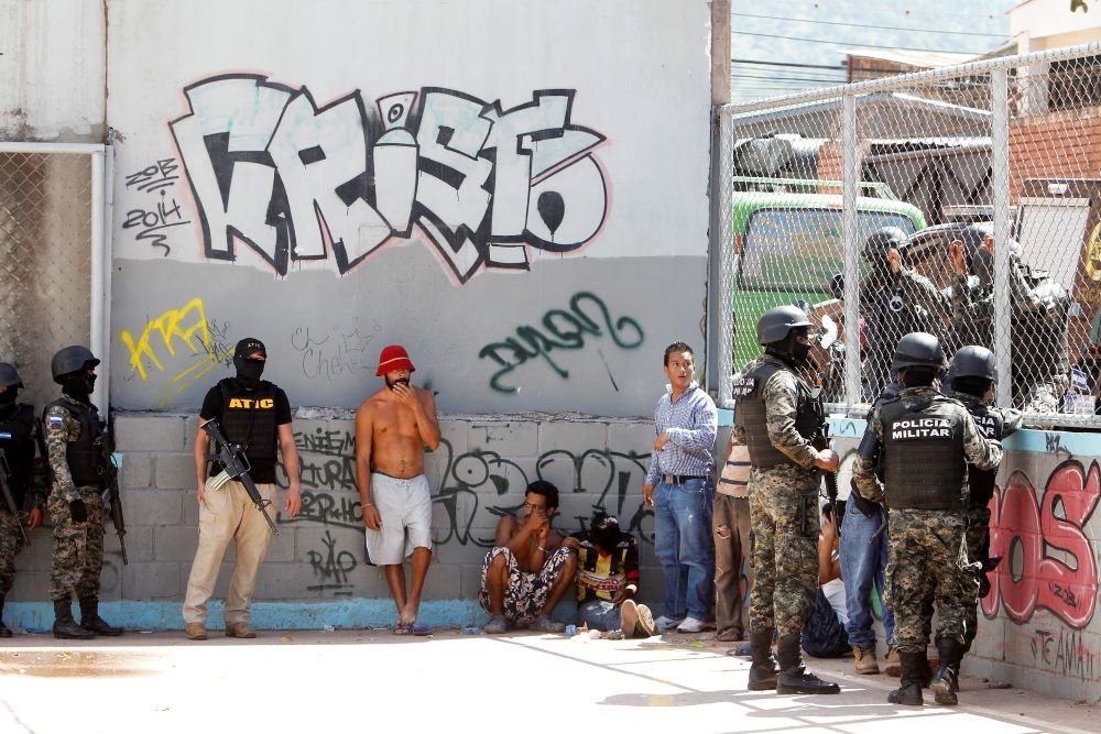 Military police in Tegucigalpa, Honduras, keep watch on suspected MS-13 gang members in this 2016 photo. (CNS/Reuters/Jorge Cabrera)