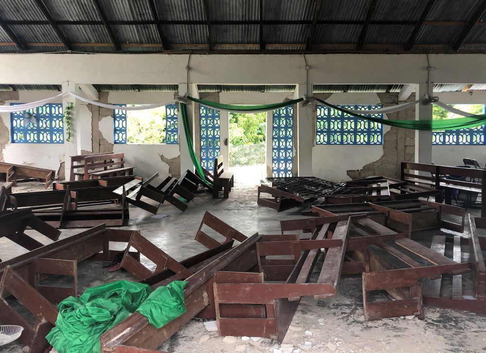 Toppled pews in the remains of St. Famille du Toirac church in Toirac, Haiti, on Aug. 16. The magnitude 7.2 earthquake that hit Haiti on Aug. 14 killed 20 people during a funeral Mass at the church. (CNS/Reuters/Laura Gottesdiener)
