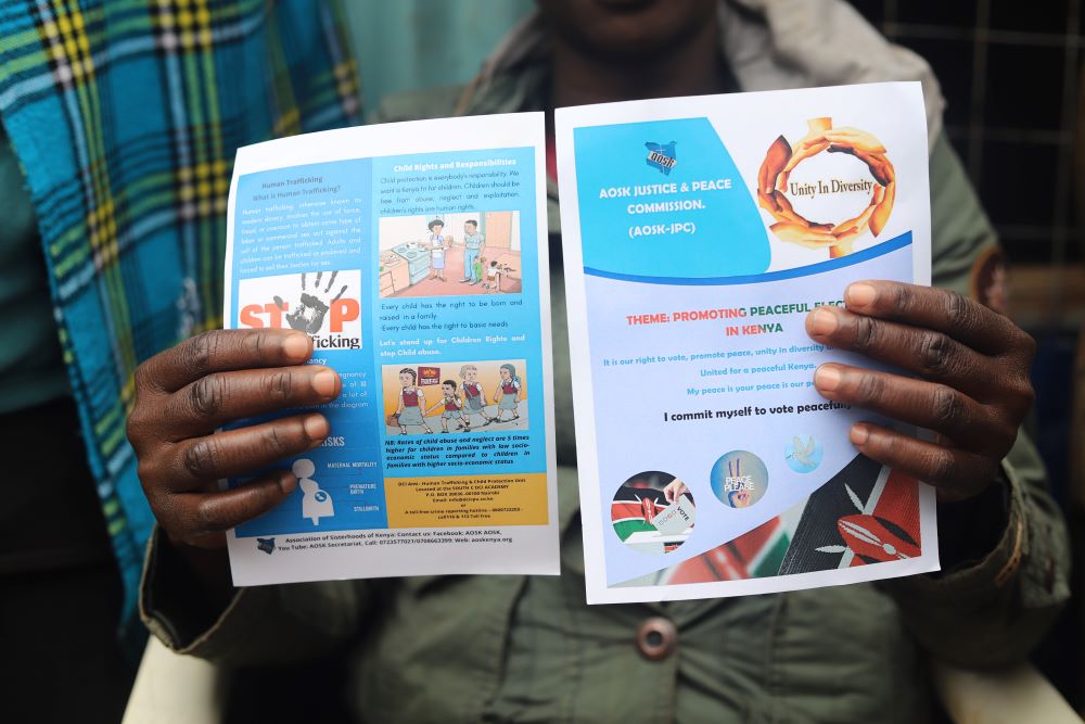 A woman displays campaign materials distributed by religious sisters on July 22 to avert violence during elections. (GSR photo/Doreen Ajiambo)