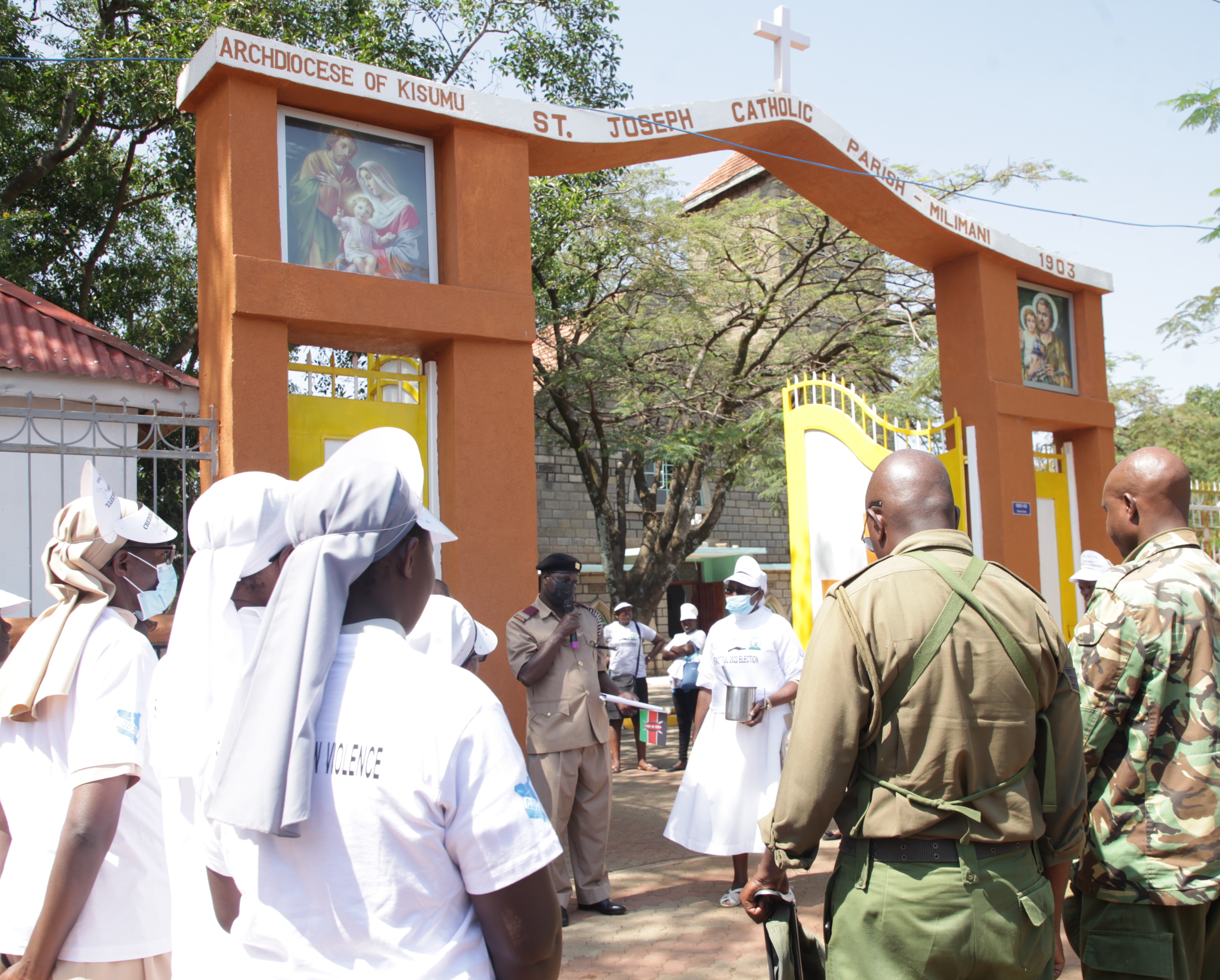 Franciscan Sisters of St. Anna and security officers bow for prayers and blessings in front of St. Joseph Catholic Church in Milimani, Kisumu, Kenya, on July 16 ahead of the peace caravan walk. (Vincent Aduda)