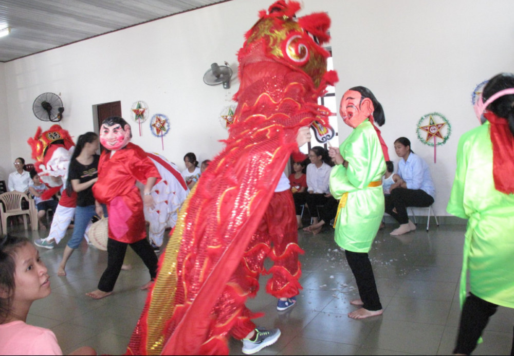 Five sisters of the Daughters of Our Lady of the Visitation perform a lion dance in colorful costumes to bring good luck and fortune to 30 children in their community in the Huong Thuy district of Thua Thien Hue province Sept. 7.