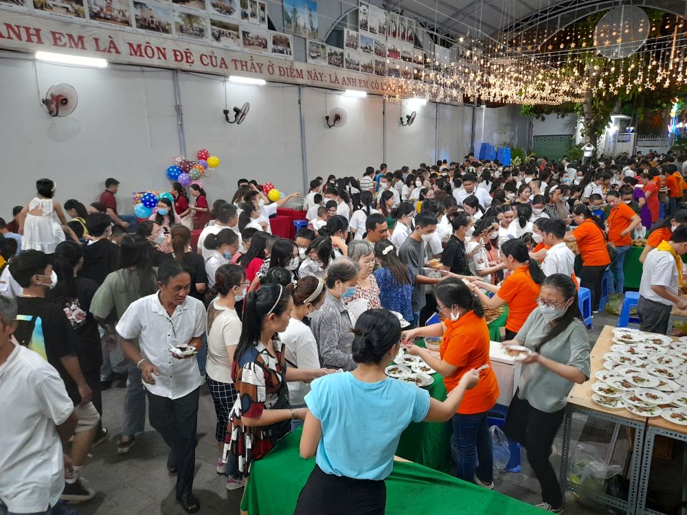 Children and their parents enjoy traditional food served by Our Lady's Immaculate Heart sisters and catechists at Bac Thanh Church in Khanh Hoa province Sept. 11. (GSR photo/Joachim Pham)
