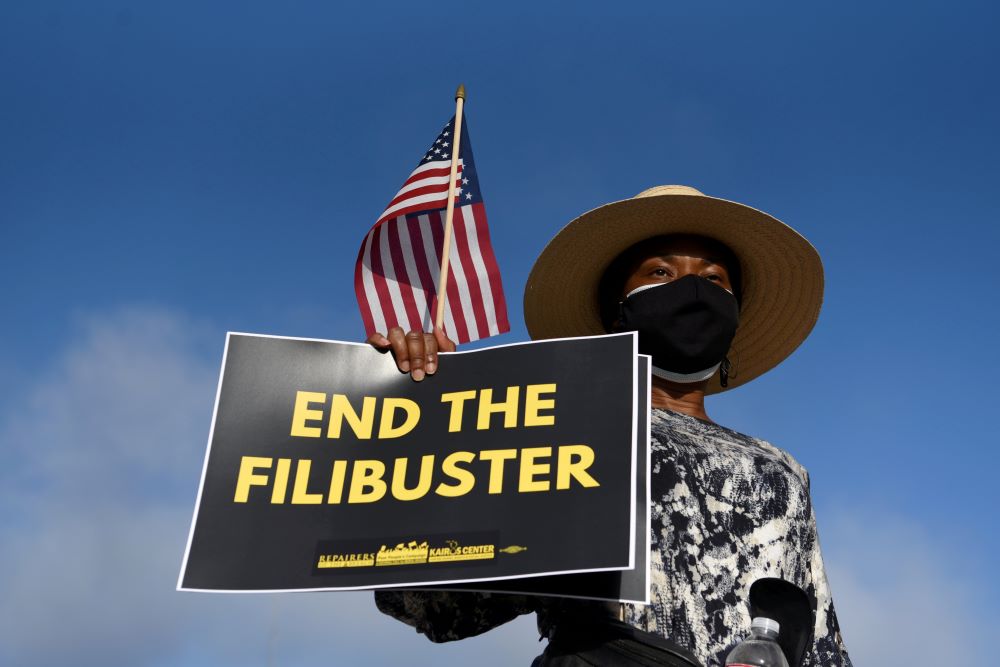 A protester holds a sign ahead of a July 31 march for voting rights in Austin, Texas. (CNS/Reuters/Callaghan O'Hare)