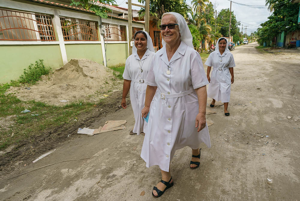 Srs. Jessica Karina Lemus Sánchez, María Luisa Canencia Garcia,  and Ana Felipa Olvera Pérez walk through the streets of Barrio La Primavera where they live and serve the children of families who work in the clothing factories of Choloma, Honduras. (Gregg