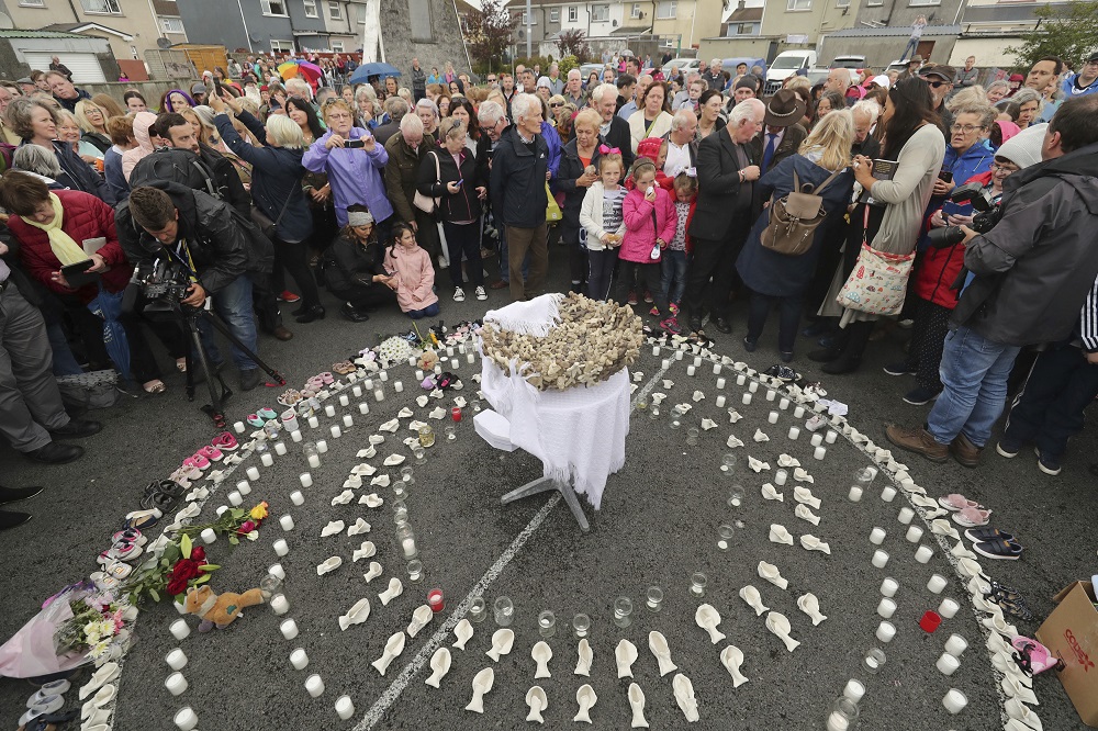 People gather Aug. 26, 2018, to protest at the site of the former Tuam home for unmarried mothers in County Galway, Ireland. (PA via AP/Niall Carson)