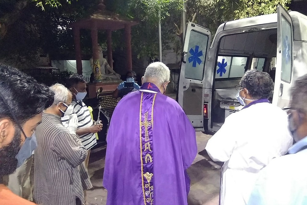 Priests pray over the body of Fr. Jerry Sequeira before his cremation in Ahmedabad, India, on April 18.