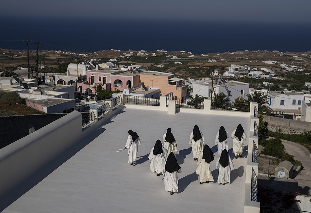 Cloistered nuns walk on a terrace of the Catholic Monastery of St. Catherine on the Greek island of Santorini on June 14. Twice a day, the nuns recess to chat on the convent's wide terraces, the Aegean Sea shimmering in the distance. (AP)