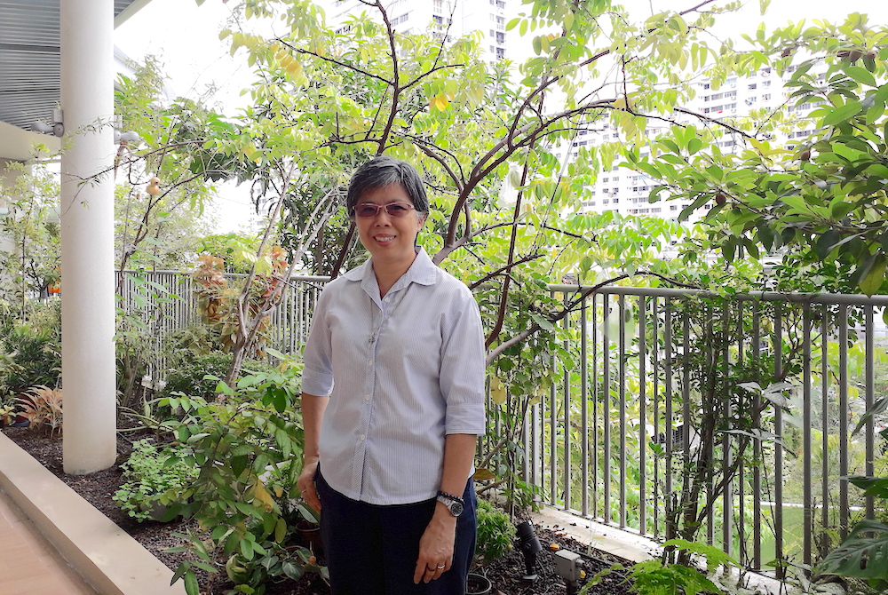 Good Shepherd Sr. Agnes-Claire Koh poses in front of the Good Shepherd Sisters' main convent; public housing can be seen in the background. (Provided photo)