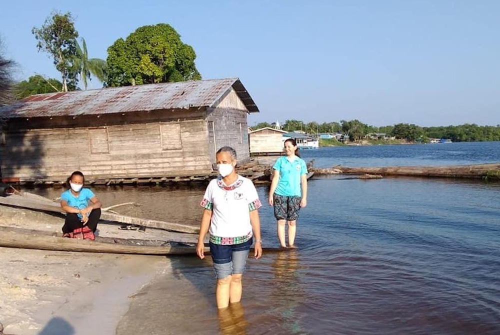 Sr. Alessandra dos Santos Santana of the Little Sisters of the Immaculate Conception, left, with volunteers in July 2020 along the riverbanks of the Solimões River in the San Francisco community, the oldest in the region (Courtesy of Sr. Alessandra dos Sa