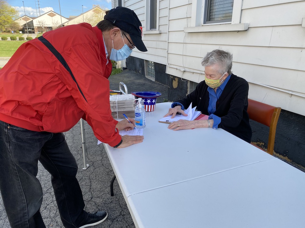 Humility of Mary Sr. Ann McManamon, right, works the voter registration table outside the Dorothy Day House of Hospitality in Youngstown, Ohio. The center set up its table on the sidewalk to register voters three days a week, before the Oct 5 deadline in 