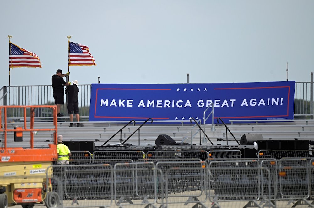 Following President Donald Trump's announcement he tested positive for the coronavirus disease, workers in Sanford, Florida, pull down signage at Orlando Sanford International Airport where the president was to have a rally Oct. 2. (CNS/Reuters/Phelan Ebe